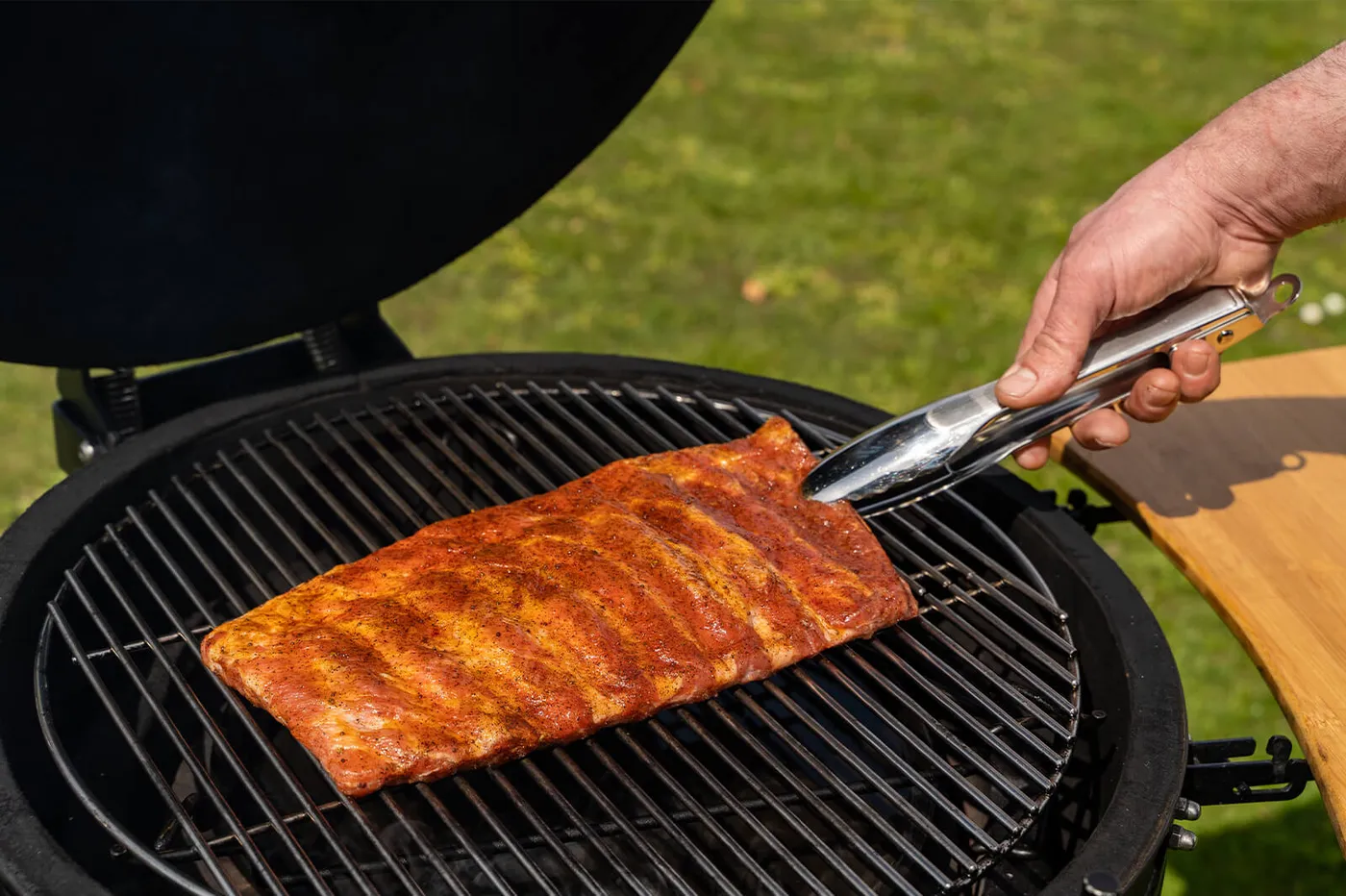 Belly ribs op de barbecue met de vleeskant naar boven gericht