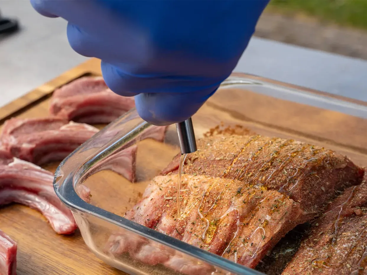 Olijfolie over het lamsvlees schenken voor de marinade