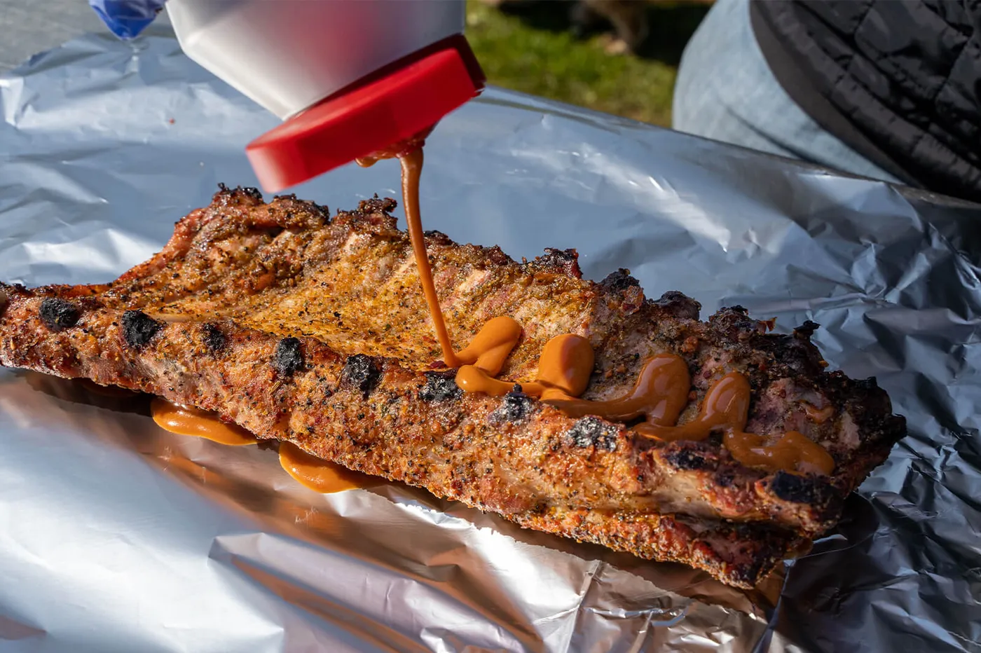 Spareribs met de vleeskant in de saus op de folie leggen