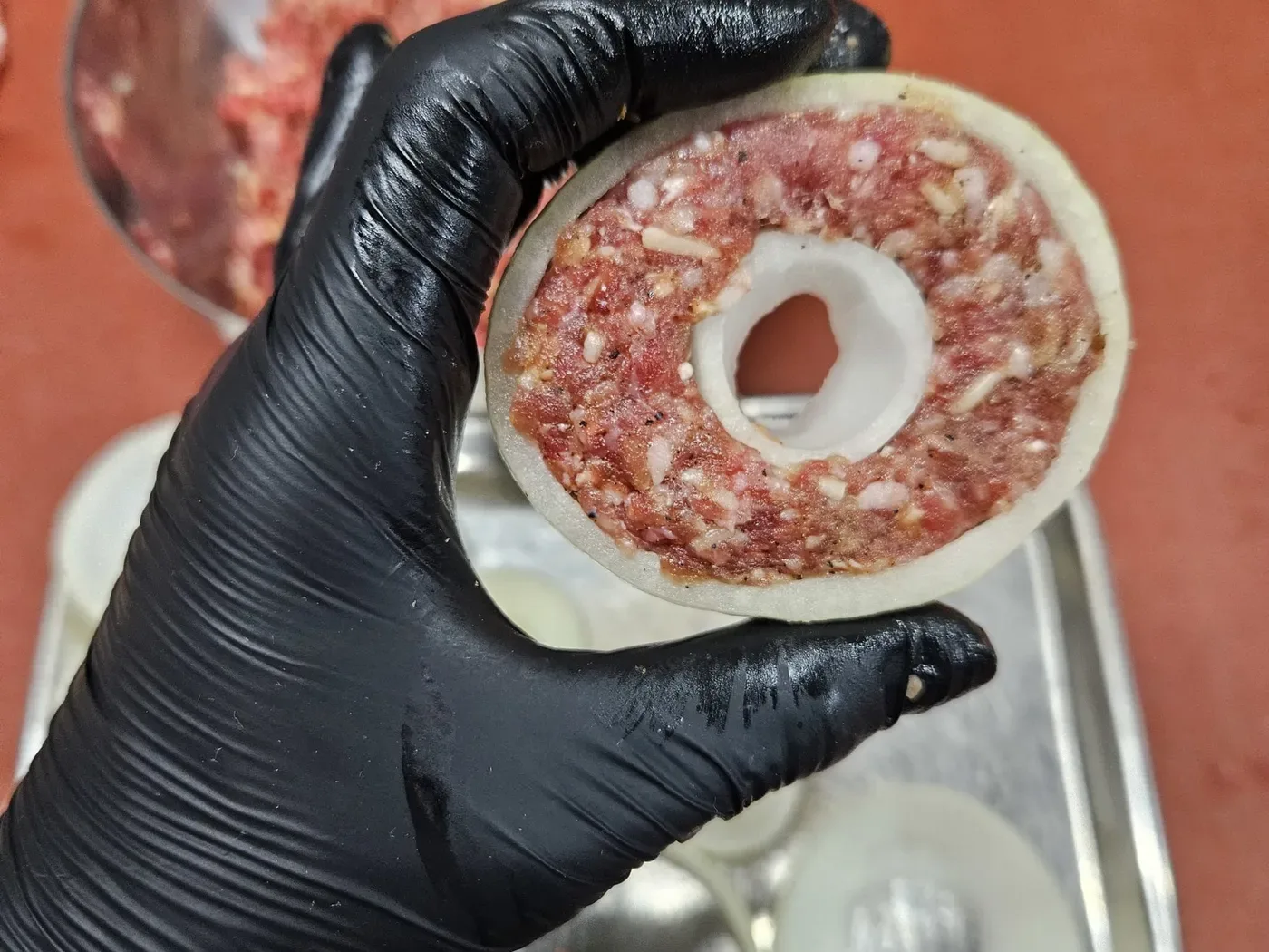 Uienringen gevuld met een randje gekruid gehakt, klaar om ingepakt te worden.