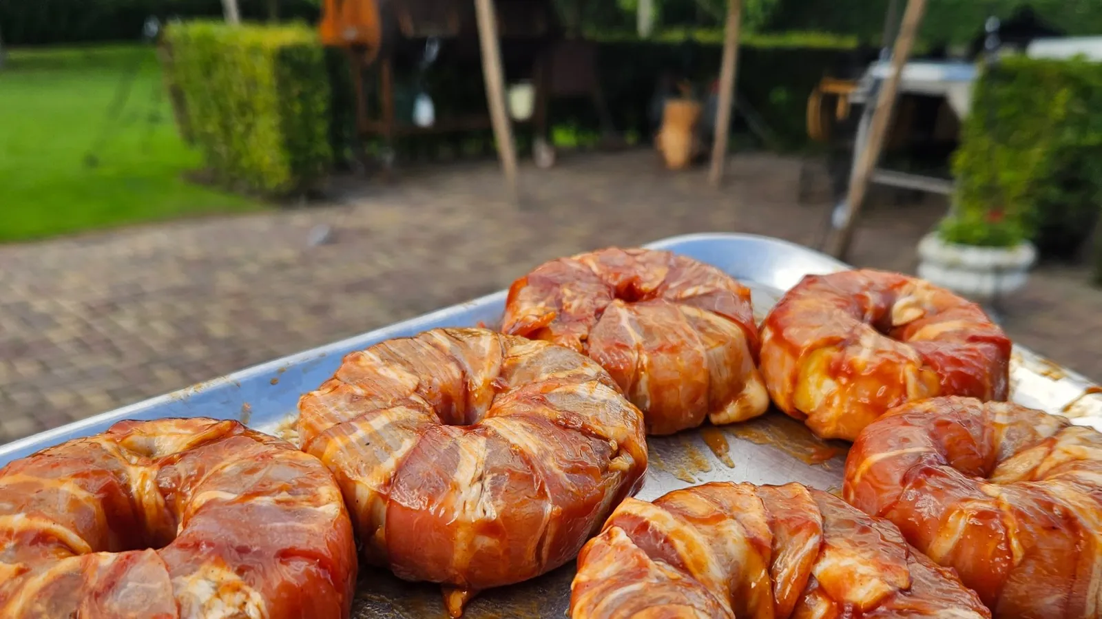 Krokante, met spek omwikkelde uienringen vers van de barbecue.