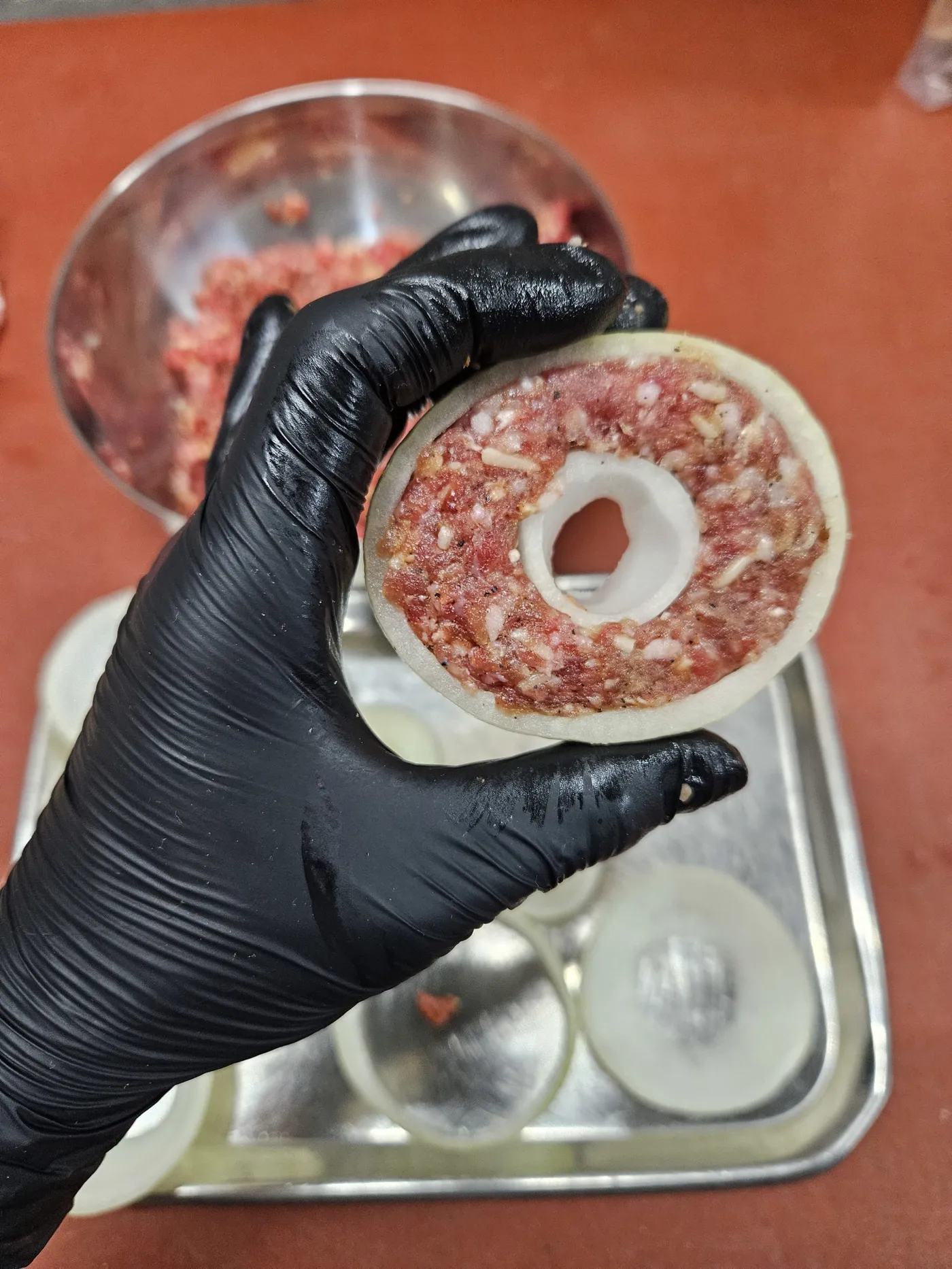 Uienringen gevuld met een randje gekruid gehakt, klaar om ingepakt te worden.