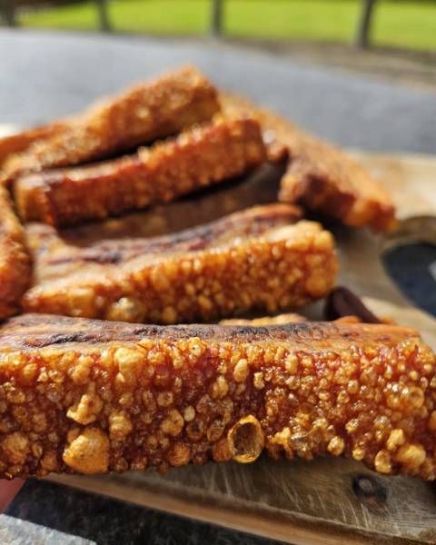 Repen rauw buikspek met zwoerd op een snijplank, klaar voor chicharron