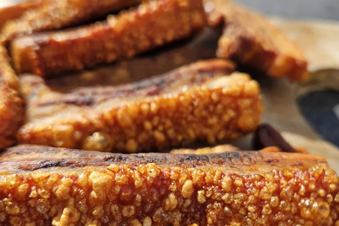 Repen rauw buikspek met zwoerd op een snijplank, klaar voor chicharron