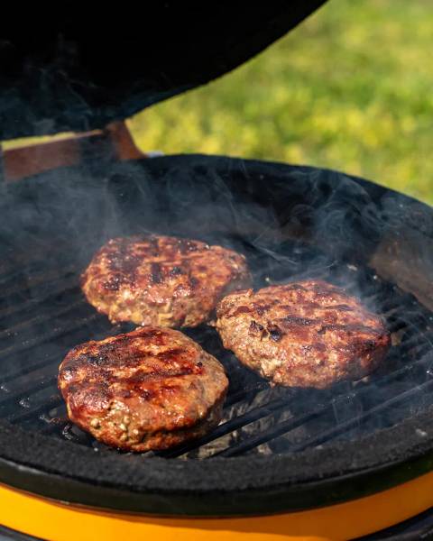 Heerlijke runderburgers die gebakken worden op de barbecue