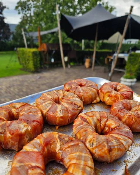 Krokante, met spek omwikkelde uienringen vers van de barbecue.